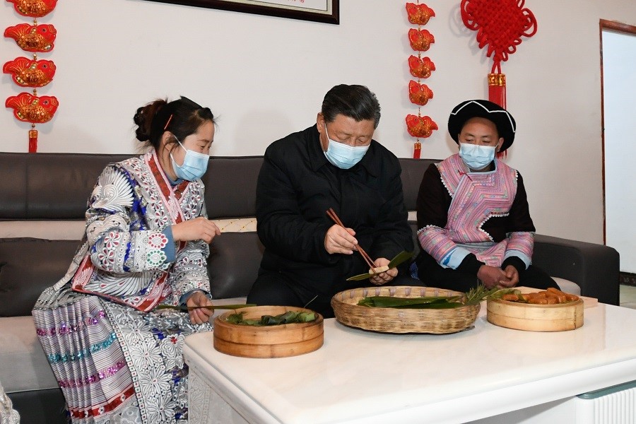2021年2月3日下午，習(xí)近平在貴州畢節(jié)市黔西縣新仁苗族鄉(xiāng)化屋村苗族村民趙玉學(xué)家，同一家人邊聊家常邊制作當(dāng)?shù)貍鹘y(tǒng)節(jié)日食品黃粑。新華社記者 李學(xué)仁 攝