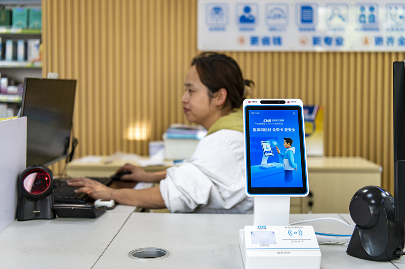 2024年4月10日，浙江金華市區(qū)一家民眾大藥房柜臺(tái)上設(shè)置著醫(yī)?！八⒛樦Ц丁睓C(jī)器，群眾看病更加便利。